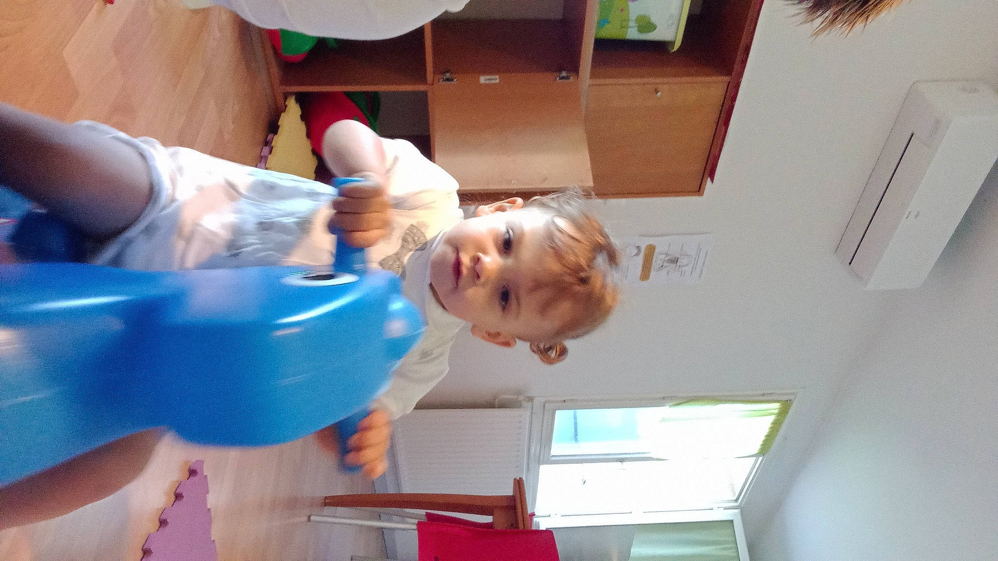 Ophélie participe au concours pour gagner de l'argent avec cette photo : baby, baby_products, baby_toddler_clothing, child, elbow, electric_blue, fun, joint, person, plastic, play, room, smile, t_shirt, toddler, vacation, window, wood