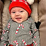 Wyatt is registered to the contest to win money with this photo: baby, smiling, hat, pom_pom, candy_cane, holiday_clothing, gray_sweater, red_and_black_plaid, infant, cute, cheerful, face, cushion, seat, clothing, portrait, indoors, child, happy, red_hat