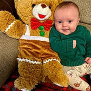 Wyatt joined the competition — help win amazing prizes! baby, teddy_bear, plush_toy, green_sweater, couch, blanket, holiday, festive, smile, child, indoor, cute, cozy, red_bow_tie, pants, patterned_clothing, furniture, happy, portrait, soft_toy