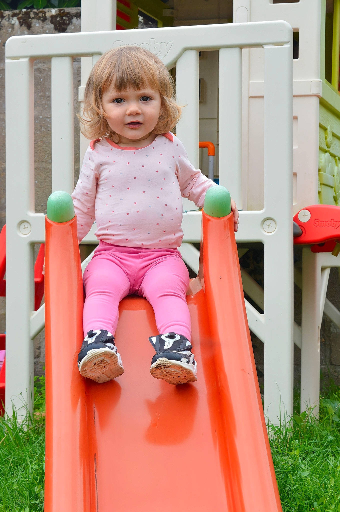 Selena participe au concours pour gagner de l'argent avec cette photo : baby_toddler_clothing, child, chute, fun, grass, happy, leisure, magenta, outdoor_play_equipment, peach, people_in_nature, person, pink, plant, play, playground, recreation, sitting, summer, toddler
