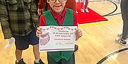 Ezekiel is registered to the contest to win money with this photo: child, certificate, school, gym, award, people, indoor, floor, shoes, glasses, clothing, red_carpet, group, celebration, person, smile, tie, wood_floor, background, event