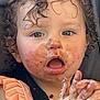 toddler, child, curly_hair, messy_face, blue_eyes, open_mouth, peach_clothing, ruffles, black_strap, sticky_hands, food_stains, face, expression, closeup, portrait, indoor, cute, young_child, skin, hand