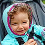 Giulia a rejoint le concours — aidez-le/la à gagner de superbes lots ! toddler, child, smiling, curly_hair, jacket, hood, stroller, snack, hand, outdoor, forest, greenery, nature, happy, cute, seatbelt, baby, person, portrait, playful