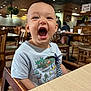 toddler, child, high_chair, restaurant, wooden_chair, table, smiling, happy, indoors, casual_clothing, cute, baby, person, mouth_open, dining, food_court, seated, daylight, expression, playful