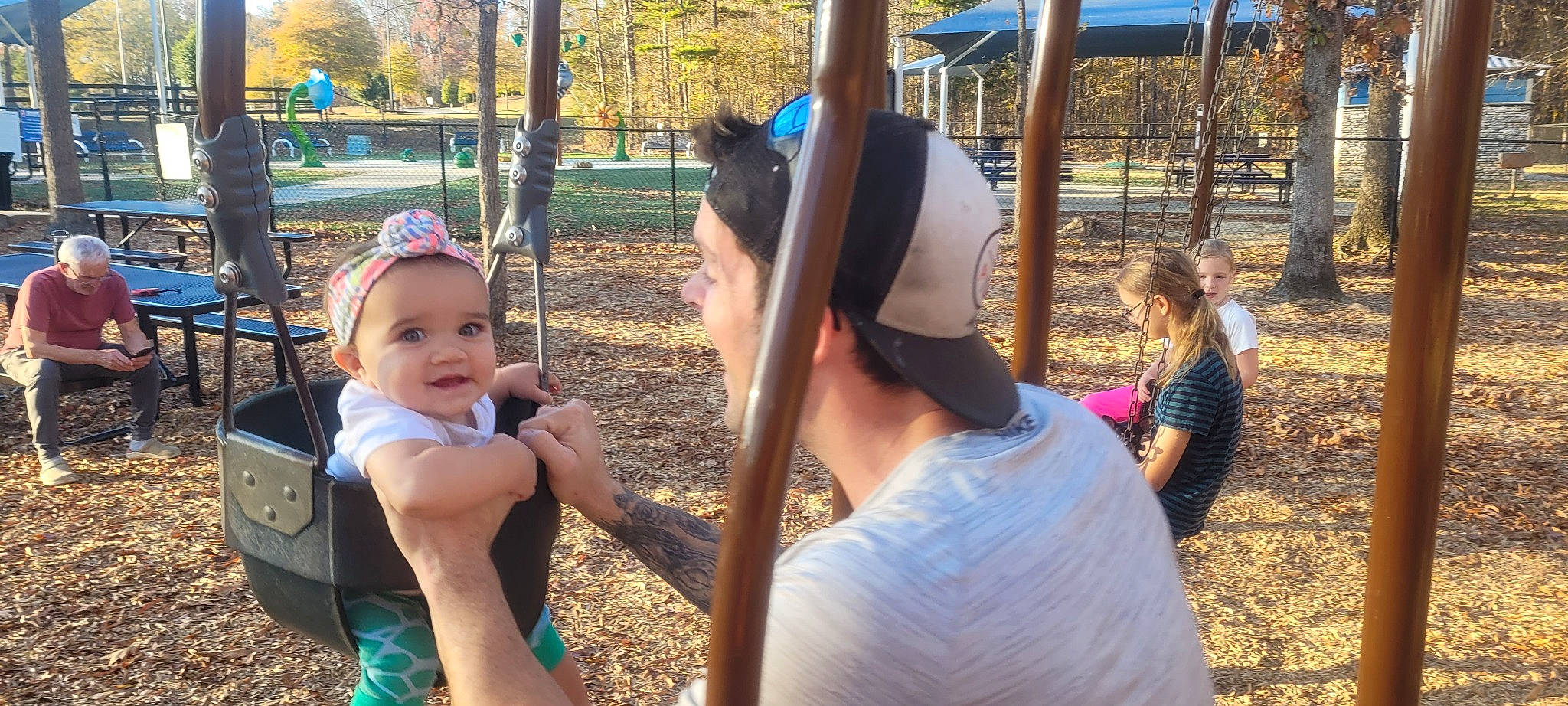 Kandace is registered to the contest to win money with this photo: cap, child, city, fun, grass, happy, hat, headwear, leisure, outdoor_play_equipment, person, plant, play, playground, public_space, recreation, smile, swing, t_shirt, toddler