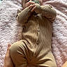 baby, infant, onesie, pacifier, blanket, hand, foot, soft_texture, bed, sleepwear, person, child, cute, lying_down, resting, indoor, skin, comfort, care, toddler