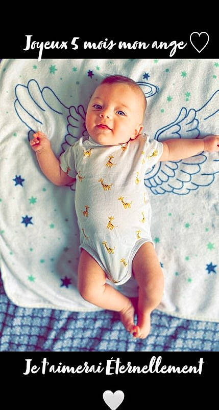 Tyliano participe au concours pour gagner de l'argent avec cette photo : baby, baby_products, baby_toddler_clothing, child, comfort, finger, font, happy, infant_bodysuit, linens, pattern, person, photo_caption, pink, room, sitting, skin, sleeve, t_shirt, textile