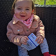 Téa a rejoint le concours — aidez-le/la à gagner de superbes lots ! baby, child, smiling, outdoor, seat, jacket, scarf, hands, clothing, face, person, sunlight, election_card, patterned_pants, red_socks, woven_chair, happy, cute, portrait, daylight
