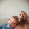 toddler, child, man, pacifier, shirtless, couch, indoor, relaxing, portrait, curly_hair, goatee, blue_clothing, facial_hair, closeup, family, casual, home, resting, person, childhood
