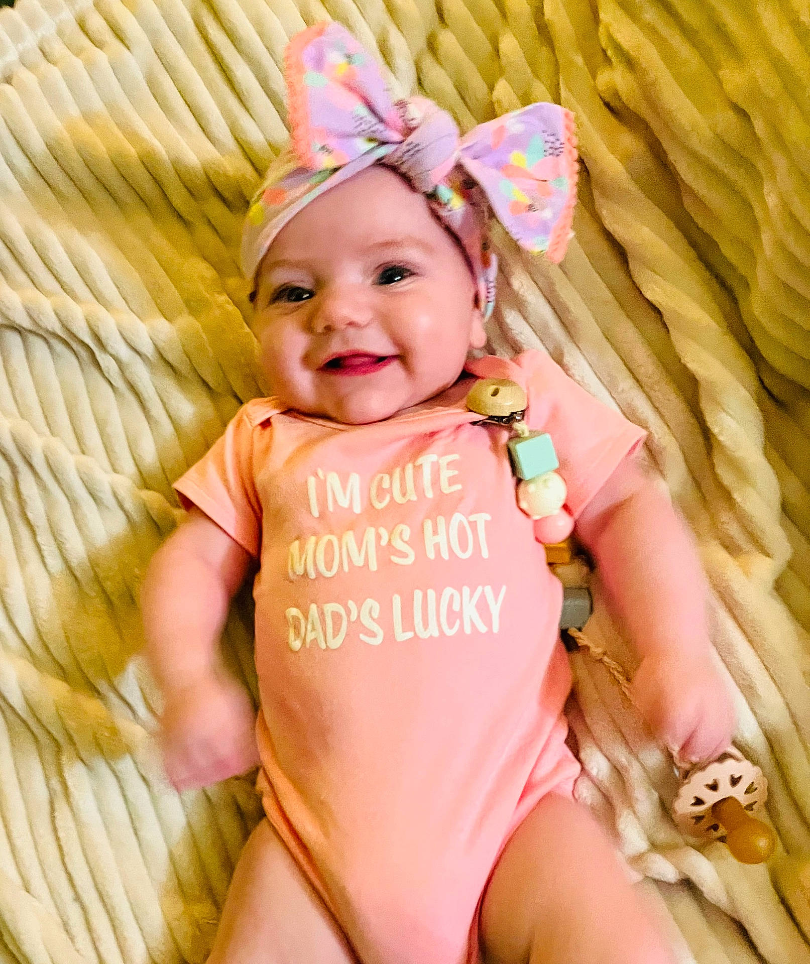 accessories, baby, bed, bonnet, cap, clothing, couch, face, furniture, happy, hat, head, homedecor, newborn, person, photography, portrait, sitting, smile, t_shirt