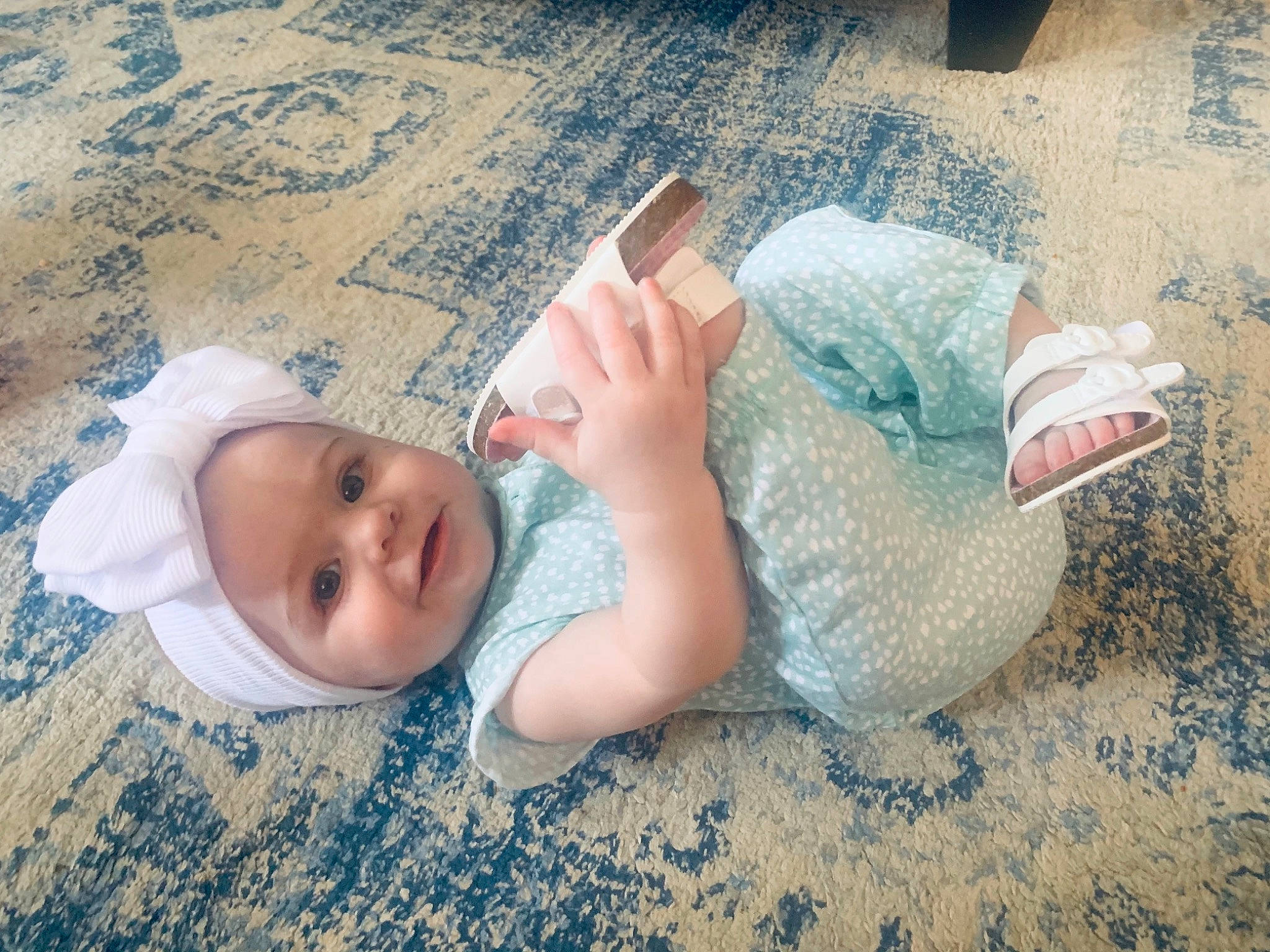 Jolene is registered to the contest to win money with this photo: baby_toddler_clothing, chin, comfort, dress, eye, finger, floor, flooring, gesture, happy, head, headgear, headwear, human_body, mammal, nose, person, skin, textile, toddler