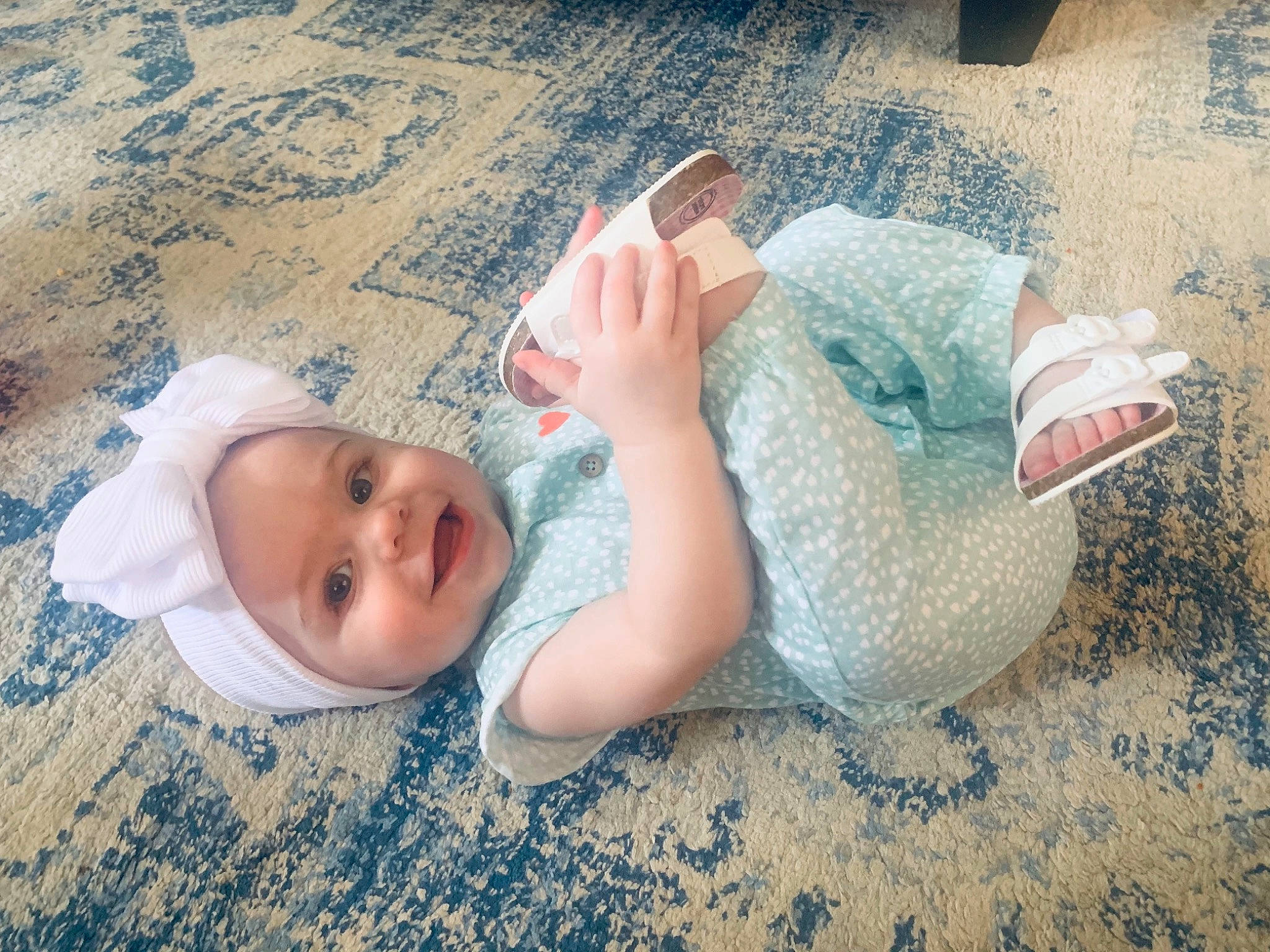 Jolene is registered to the contest to win money with this photo: baby, baby_toddler_clothing, barefoot, child, comfort, floor, flooring, foot, fun, gesture, grass, happy, headgear, headwear, human_body, human_leg, mammal, person, skin, smile