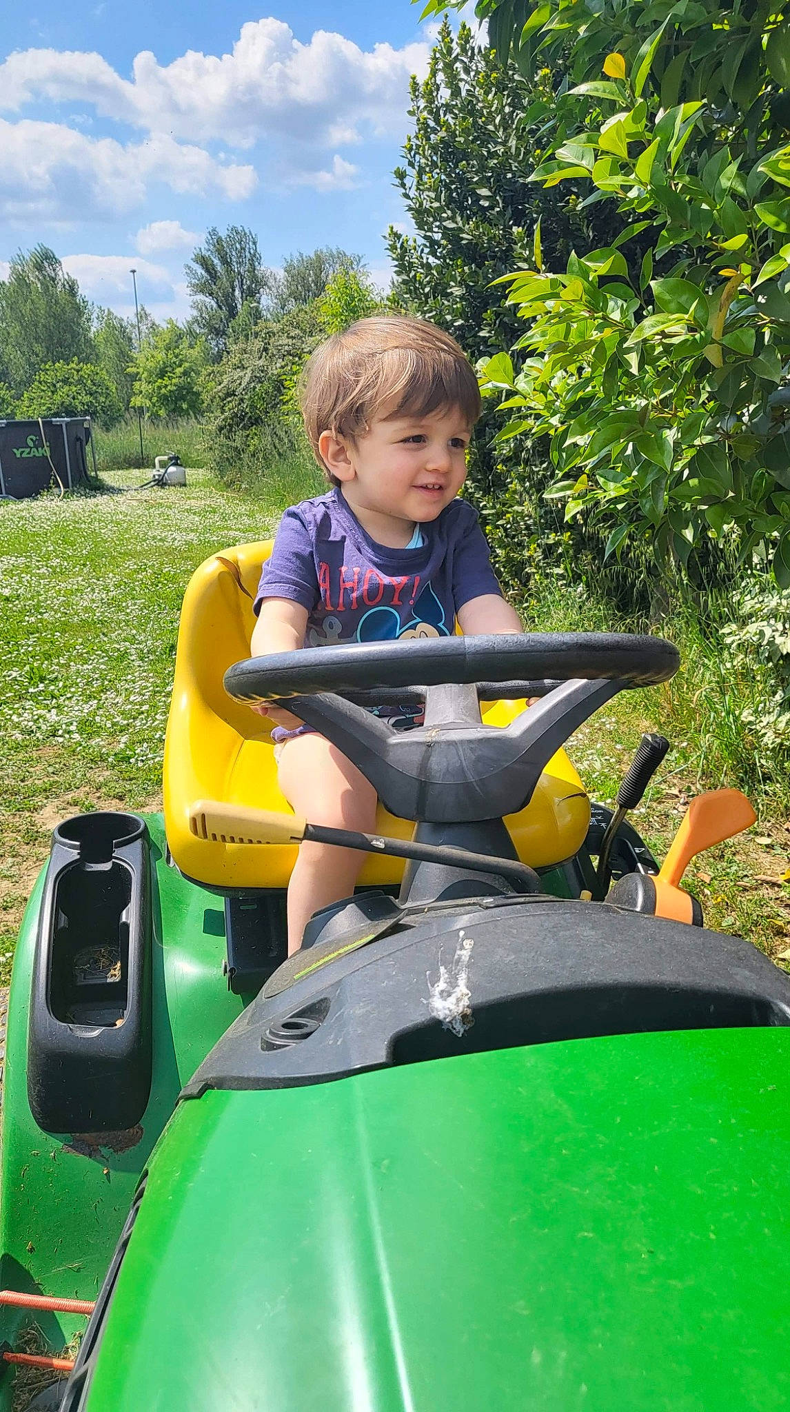 Logan participe au concours pour gagner de l'argent avec cette photo : automotive_design, automotive_exterior, automotive_tire, cloud, grass, happy, joy, lawn, leaf, leisure, motor_vehicle, nature, person, personal_protective_equipment, plant, recreation, riding_toy, sky, smile, toddler