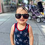 Matthew joined the competition — help win amazing prizes! child, toddler, sunglasses, tank_top, stars_pattern, smiling, outdoor, sidewalk, urban, stroller, sunny, daylight, casual_clothing, happy, person, portrait, childhood, summer, fashion, cute