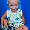 blue_slide, boots, casual_clothing, child, curly_hair, cute, daylight, expression, fish_pattern, fun, legs_crossed, outdoor, playground, playtime, portrait, sitting, smudged_face, summer, toddler, young_child