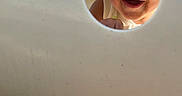 Cain is registered to the contest to win money with this photo: child, closeup, curious, daylight, expression, eyes, face, fun, happy, hole, innocence, mouth, outdoor, peeking, play, playground, skin, smile, toddler, white_clothing