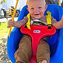 baby, barefoot, blue_swing, child, face, grass, little_tikes, outdoors, pants, play, portrait, red_toy, seat, smile, straps, sunlight, swing, toddler, tree, yellow_rope