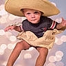 Cain is registered to the contest to win money with this photo: baby, background, bokeh, child, clothing, face, fashion, hat, legs, outdoor_style, photography, playful, portrait, shirt, shorts, sitting, smiling, sombrero, sun_hat, toddler