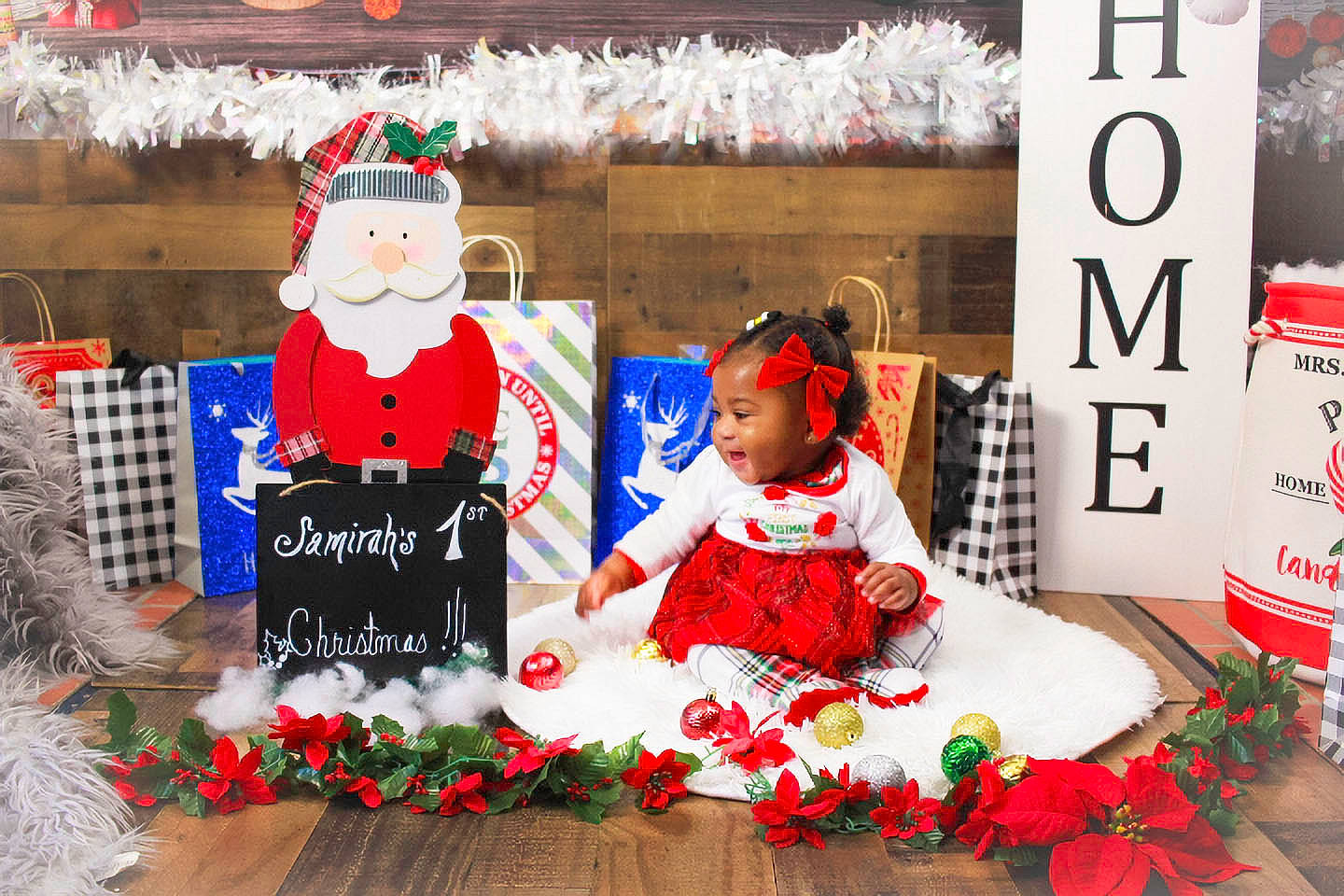 Samirah is registered to the contest to win money with this photo: baby_toddler_clothing, carmine, christmas, christmas_decoration, christmas_eve, christmas_ornament, event, fictional_character, happy, hat, holiday, party_supply, person, red, room, santa_claus, toddler, tradition, tree, window