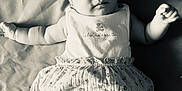 Alba participe au concours pour gagner de l'argent avec cette photo : baby, infant, child, clothing, dress, fabric, blanket, portrait, face, skin, smile, hand, arm, lying_down, cute, young, indoors, soft_lighting, monochrome, expression