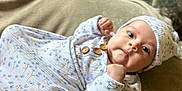Abby is registered to the contest to win money with this photo: baby, infant, child, onesie, hat, blanket, fabric, soft, indoor, portrait, person, cute, cozy, fist, gaze, clothing, resting, young, newborn, lying