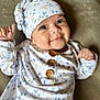 Abby joined the competition — help win amazing prizes! baby, infant, smiling, hat, clothing, buttons, pattern, floral, soft, cute, portrait, closeup, child, lying_down, happy, indoors, warm, cozy, person, newborn