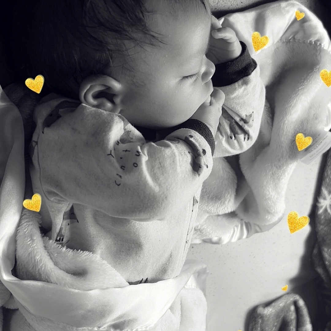Cameron is registered to the contest to win money with this photo: baby, sleeping, blanket, heart_overlay, black_and_white, infant, soft_texture, peaceful, cute, child, clothing, resting, portrait, indoors, young_child, cozy, toddler, head, face, hand