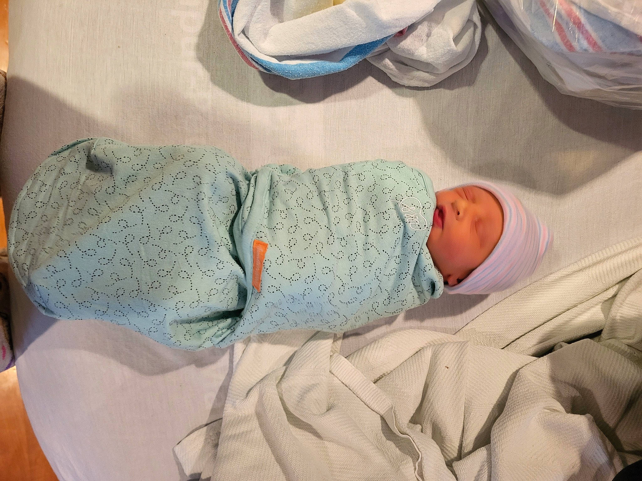 Lewis is registered to the contest to win money with this photo: baby, baby_products, baby_sleeping, baby_toddler_clothing, bedding, bedtime, child, comfort, hat, headwear, health_care, hospital, human_body, human_leg, linens, nap, person, room, sleep, sleeve