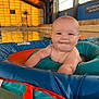 Vincent is registered to the contest to win money with this photo: baby, pool, float, water, indoor, swimming_pool, child, smiling, infant, face, skin, orange_lighting, reflection, blue, red, person, head, arm, cute, playful