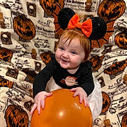Evalyna joined the competition — help win amazing prizes! baby, child, red_hair, balloon, headband, bat_wings, mouse_ears, smiling, halloween, pumpkin, blanket, costume, orange, black_clothing, cute, sitting, indoor, holiday, festive, joyful