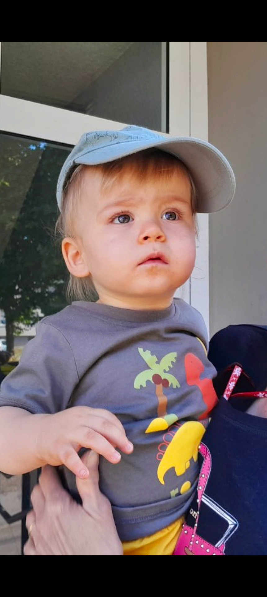 Adrien participe au concours pour gagner de l'argent avec cette photo : building, cap, child, clothing, curious, dinosaur, expression, face, gray, hand, outdoor, person, reflection, shirt, skin, support, toddler, tree, window, yellow