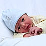 baby, infant, newborn, hat, yellow_clothing, white_background, lying_down, face, hands, skin, cute, soft, cozy, portrait, closeup, sleepwear, child, newborn_hat, baby_gaze, resting