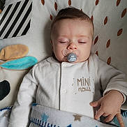 Lucas participe au concours pour gagner de l'argent avec cette photo : baby, sleeping, pacifier, blanket, star_pattern, white_clothing, hand_gesture, soft_toy, fabric, face, infant, cute, resting, indoors, child, newborn, peaceful, cozy, portrait, baby_bedding