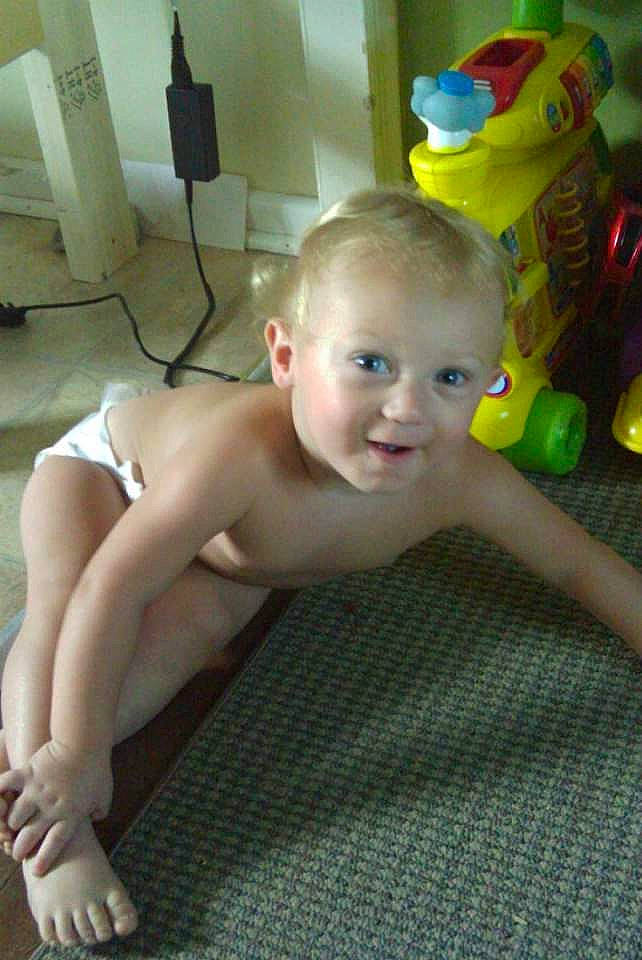 Collin is registered to the contest to win money with this photo: baby, barechested, barefoot, chest, child, floor, flooring, foot, fun, human_leg, knee, person, room, sitting, skin, smile, thigh, thumb, toddler, toy