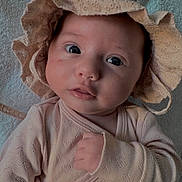 Romy participe au concours pour gagner de l'argent avec cette photo : baby, blanket, bonnet, child, closeup, clothing, cute, expression, eyes, face, gaze, hand, indoors, infant, newborn, onesie, portrait, skin, sleepwear, soft_texture