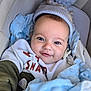 Tobias is registered to the contest to win money with this photo: baby, blanket, blue, bundle, child, closeup, clothing, cozy, cute, face, happy, hat, indoors, infant, person, pom_pom, portrait, smiling, soft, warm