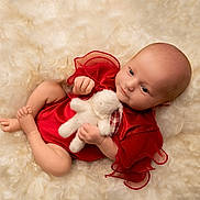 Emilia is registered to the contest to win money with this photo: baby, infant, red_clothing, plush_toy, white_bunny, soft_texture, fluffy_background, cute, child, portrait, lying_down, small_hands, small_feet, calm_expression, indoor, close_up, newborn, adorable, soft_lighting, resting
