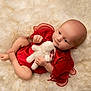 baby, infant, red_clothing, plush_toy, white_bunny, soft_texture, fluffy_background, cute, child, portrait, lying_down, small_hands, small_feet, calm_expression, indoor, close_up, newborn, adorable, soft_lighting, resting