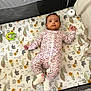 Madiha joined the competition — help win amazing prizes! animal_print, baby, calm, child, curious, cute, floral_pattern, indoor, infant, looking_at_camera, lying_down, mattress, mesh_sides, onesie, playpen, small_feet, small_hands, soft_colors, toy, white_socks