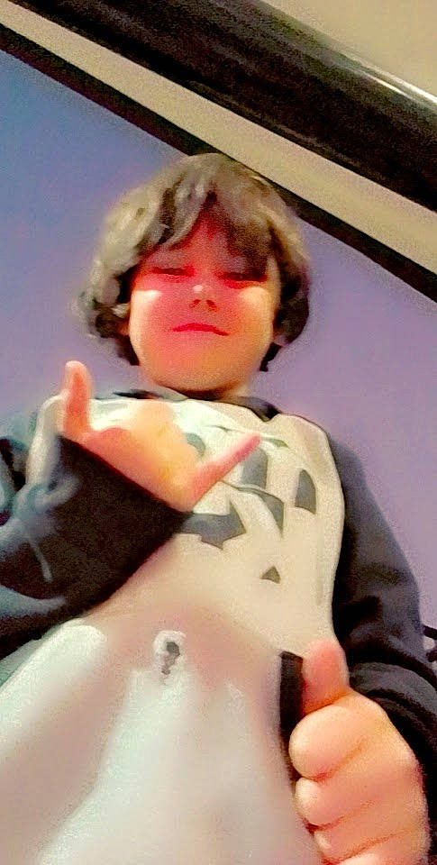 Leighton is registered to the contest to win money with this photo: abdomen, chest, comfort, elbow, eyewear, fashion_design, finger, flesh, fur, gesture, human_leg, knee, peach, person, personal_protective_equipment, room, sitting, sleeve, thigh, thumb