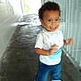 Kentrell Simmons is registered to the contest to win money with this photo: toddler, child, smiling, walking, curly_hair, white_shirt, blue_jeans, sneakers, corridor, metal_railing, tiled_wall, indoor, person, happy, motion_blur, concrete_floor, casual_clothing, young_child, portrait, daylight