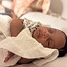 newborn, baby, sleeping, infant, portrait, close_up, towel, blanket, wrapped, bed, cozy, peaceful, face, eyes_closed, indoor, warm_lighting, relaxed, lying_down, dark_hair, nursery