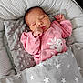 newborn, baby, sleeping, pink_outfit, blanket, pillow, star_pattern, cozy, infant, face, hand, closed_eyes, soft_texture, cute, resting, indoors, child, peaceful, wrapped, portrait