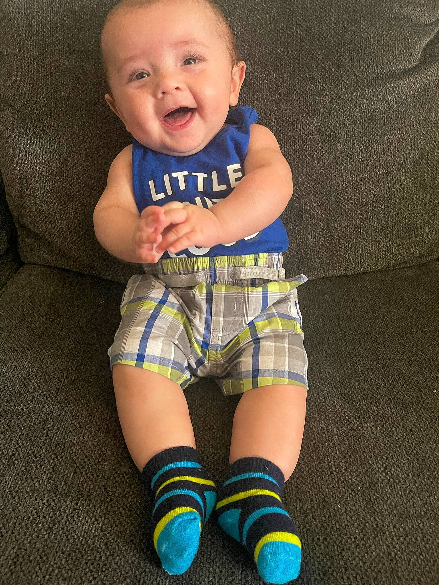 Levi is registered to the contest to win money with this photo: arm, baby_toddler_clothing, comfort, eye, face, finger, happy, head, human_body, human_leg, knee, neck, person, plaid, shorts, skin, sleeve, smile, t_shirt, thigh
