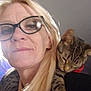 animal, blonde_hair, casual, cat, closeup, comfort, content, eyewear, face, feline, friendship, glasses, human, indoor, pet, portrait, relaxation, shoulder, tabby_cat, woman