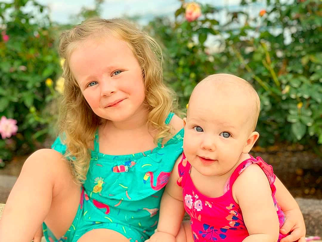 Macie is registered to the contest to win money with this photo: baby, blond, child, dress, face, family, fun, grass, joy, people, person, photography, pink, plant, play, sibling, sitting, skin, smile, summer