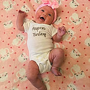 Aspen joined the competition — help win amazing prizes! baby, infant, newborn, onesie, headband, bow, pink_blanket, cat_pattern, heart_pattern, text_on_clothing, smiling, face, eyes, arms, legs, feet, lying_down, cozy, soft_texture, portrait