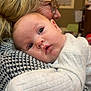 Aspen is registered to the contest to win money with this photo: baby, infant, adult_profile, glasses, cuddle, hug, blanket, sweater, knit_texture, closeup, portrait, indoors, window, lamp, skin, face, newborn, resting, cozy, family