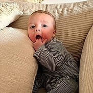Marceau participe au concours pour gagner de l'argent avec cette photo : baby, beige, child, comfort, couch, cozy, curious, face, furniture, hands, home, indoor, infant, person, pillow, portrait, sitting, soft, striped_pajamas, young_child