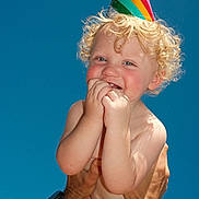 Royal joined the competition — help win amazing prizes! bare_chest, blue_sky, celebration, child, curly_hair, cute, daylight, hands, happy, joy, orange_shorts, outdoor, party_hat, person, playful, portrait, skin, smiling, summer, toddler